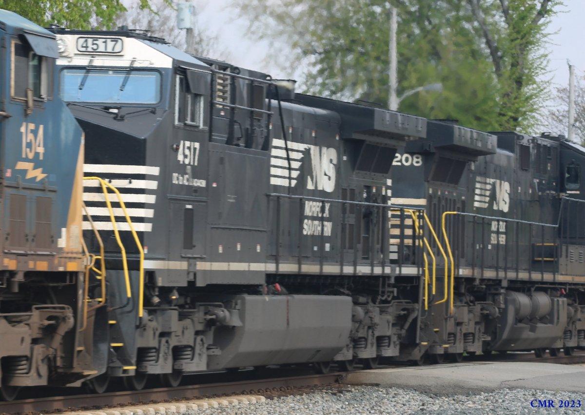Photograph of several freight locomotives, including Norfolk Southern 4517, showing their markings, handrails, and mechanical details on a multi‑track lineup. Image captured in 2023.