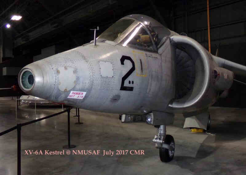 A gray XV‑6A Kestrel V/STOL test aircraft displayed indoors at the National Museum of the U.S. Air Force, shown from a front‑left angle. The large circular intake, “DANGER INTAKE” warning, and the number “2” on the nose are clearly visible. The aircraft is surrounded by stanchions inside a hangar‑style gallery.